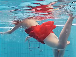 red dressed teenager swimming with her eyes opened